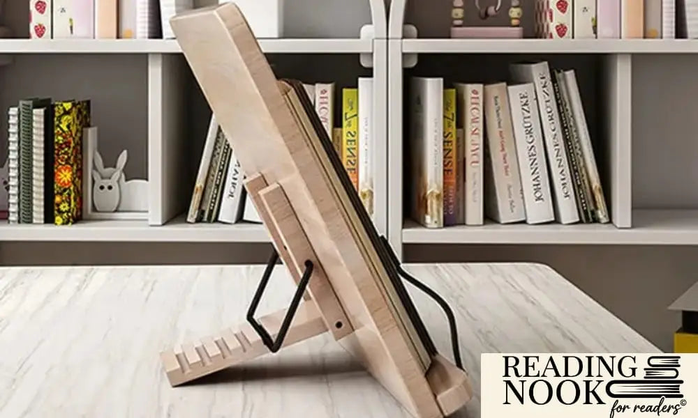 Side profile of a Reading Nook natural wood book stand on a white desk. The image shows the adjustable black metal support bar locked into a notched wooden base, allowing for multiple reading angles. A white bookshelf is visible in the background.